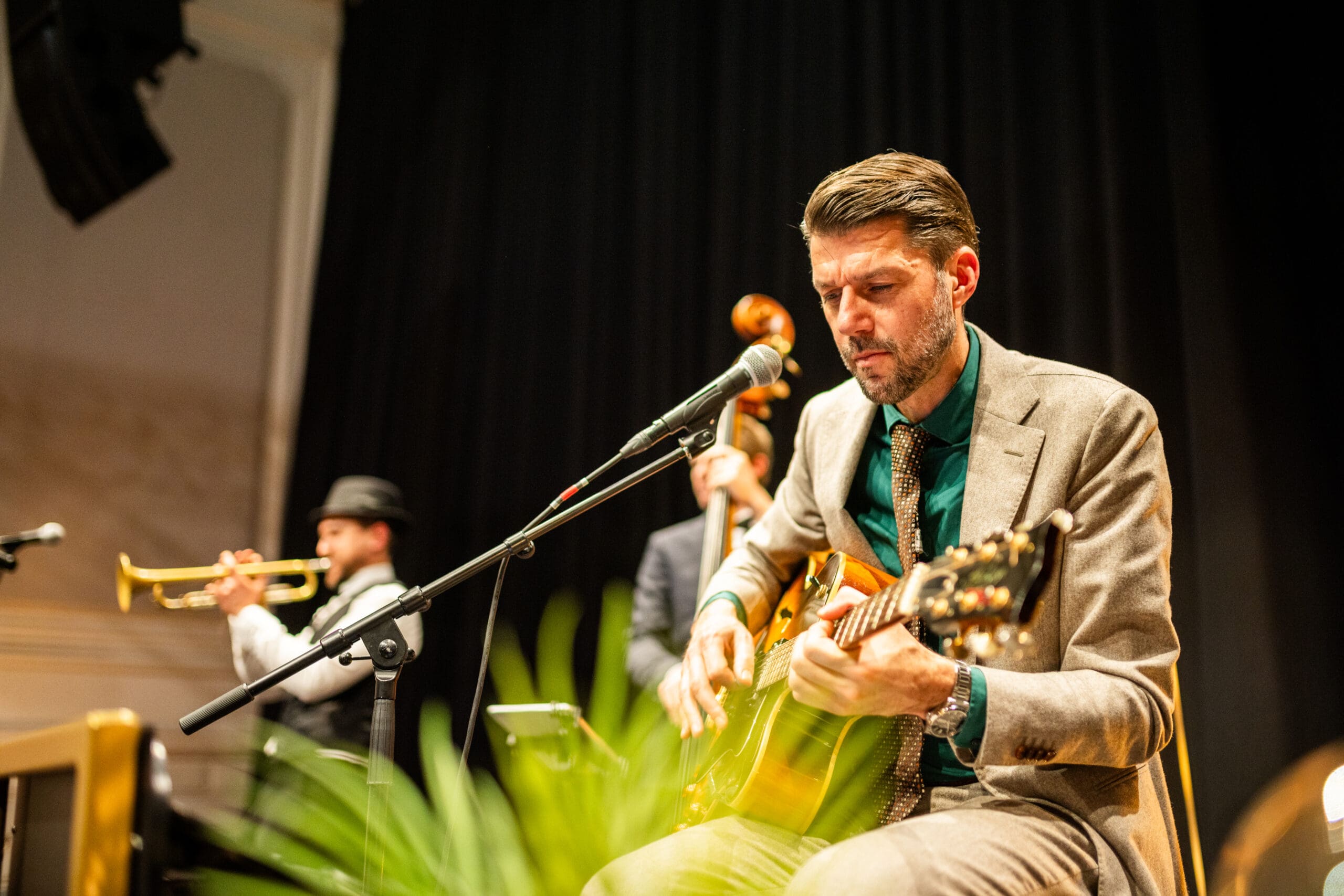 De gitarist tokkelt op zijn gitaar en kijkt met een serieuze blik