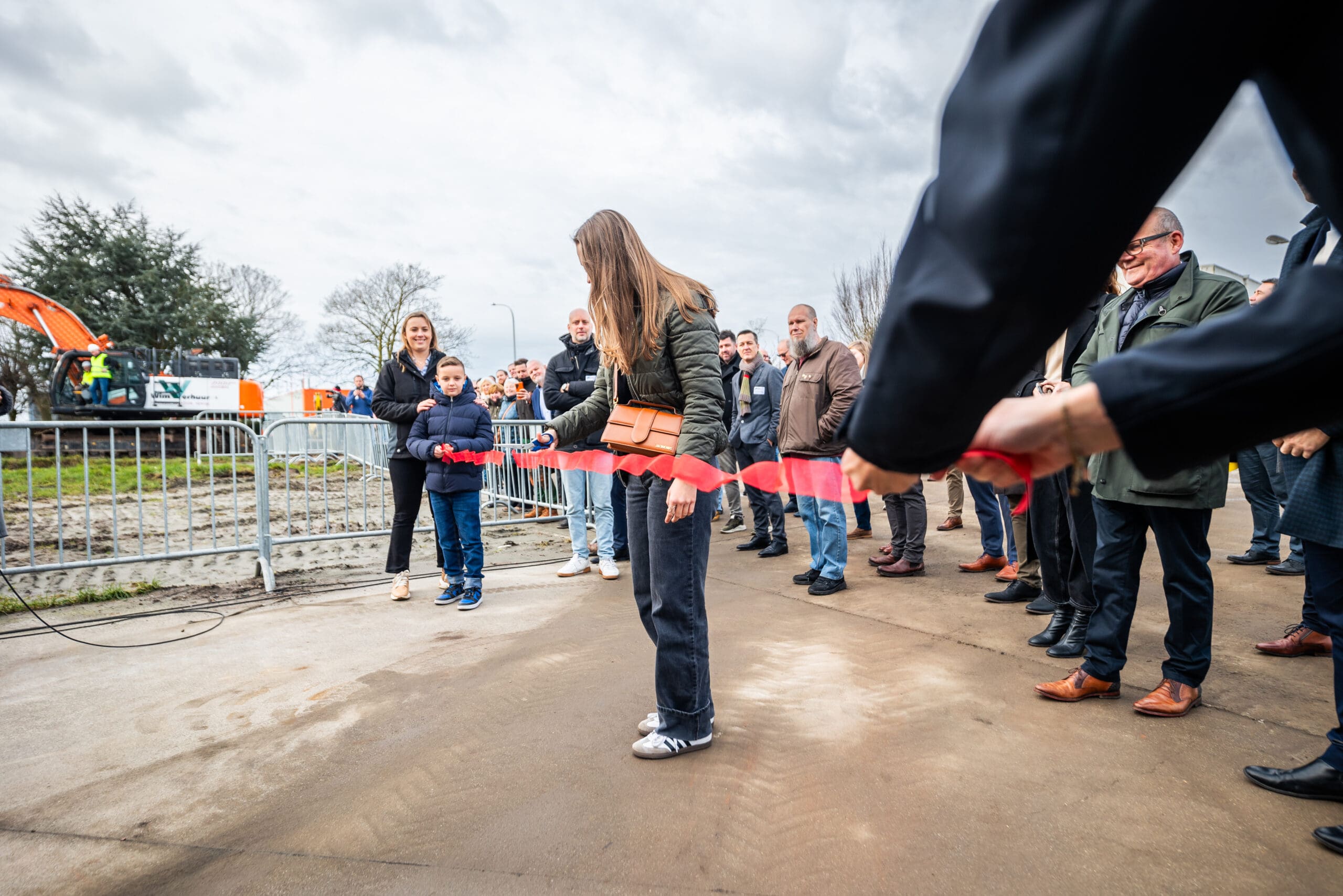 De dochter van de zaak knipt het lintje door, als officieel startschot voor het nieuwe bedrijvencentrum