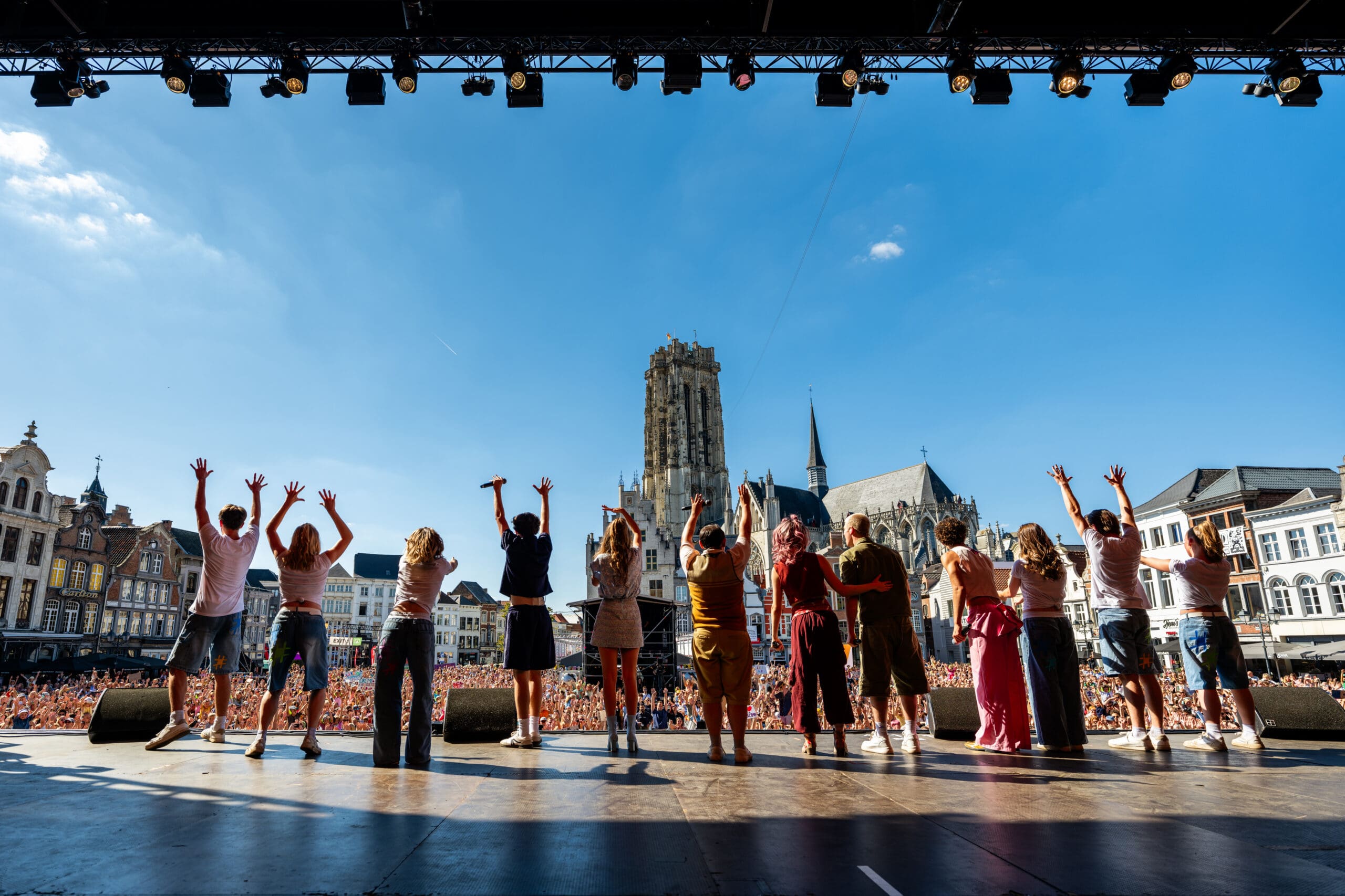 De leden van #LikeMe staan op het podium naast elkaar en zwaaien naar het publiek van Maanrock.